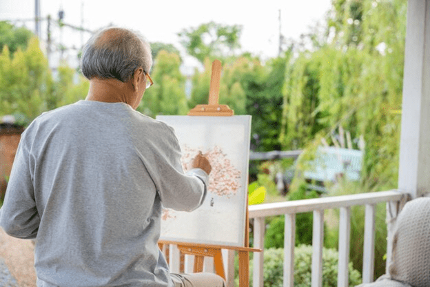 A person painting on a canvas

Description automatically generated